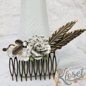 White and bronze hair comb featuring a white book